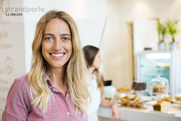 Junge Frau lächelt fröhlich in der Bäckerei  Portrait
