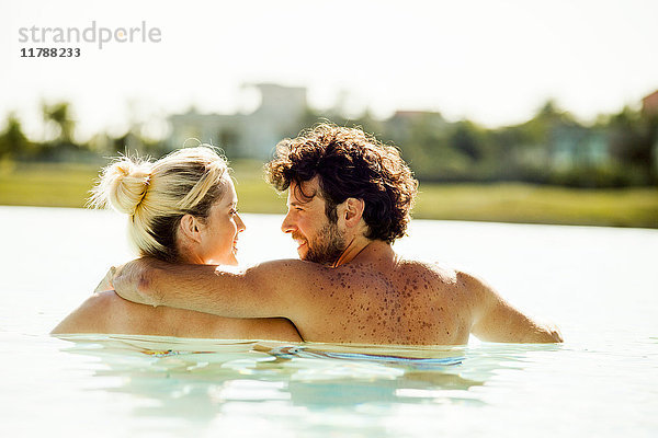 Paare  die sich im Wasser entspannen und sich gegenseitig in die Augen schauen.