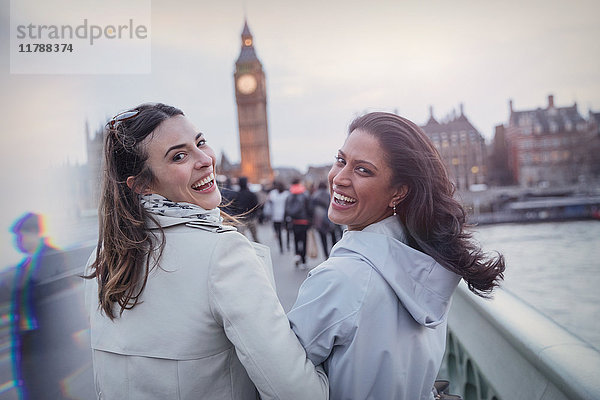 Portrait lächelnde  enthusiastische Frauen  die auf der Brücke in Richtung Big Ben  London  UK  gehen.