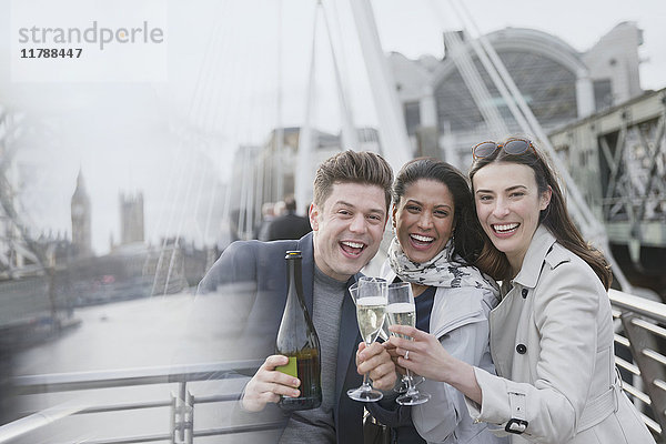 Portrait begeisterte Geschäftsleute beim Feiern  Trinken von Champagner auf der urbanen Brücke  London  UK