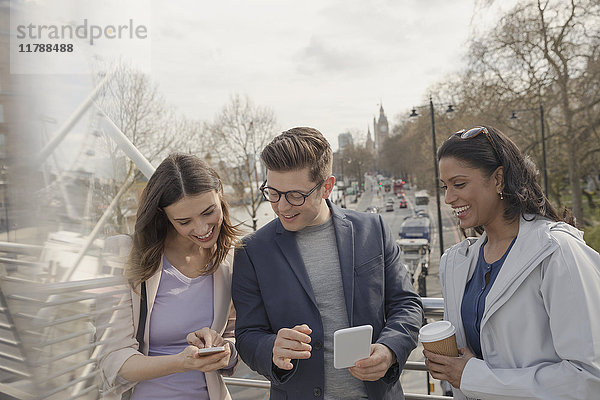Freunde  die Handys benutzen und Kaffee trinken auf der urbanen Brücke  London  UK