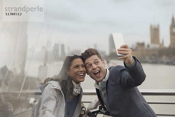 Verspieltes Paar Touristen  die Selfie mit Fotohandy auf der Brücke nehmen  London  UK