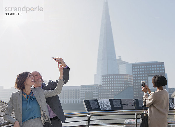 Geschäftspaar nimmt Selfie mit Fotohandy  London  UK