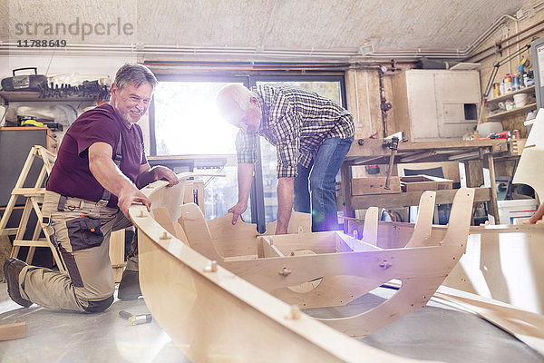 Männliche Schreiner  die in der Werkstatt Holzboote herstellen