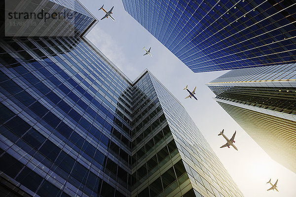 Flugzeuge fliegen in einer Reihe über Hochhäuser  Reisekonzept