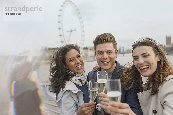 Portrait begeisterte  lächelnde Freunde beim Feiern  Trinken von Champagner am Millennium Wheel  London  UK