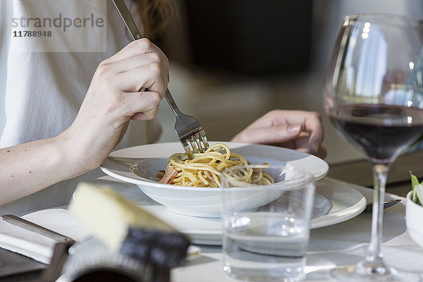 Frau isst Spaghetti Carbonara