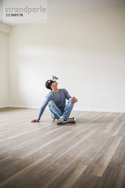 Mann in leerer Wohnung mit VR-Brille