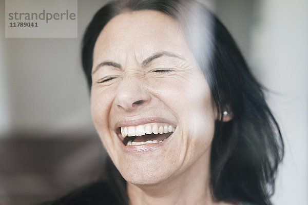 Porträt der lachenden Frau mit geschlossenen Augen