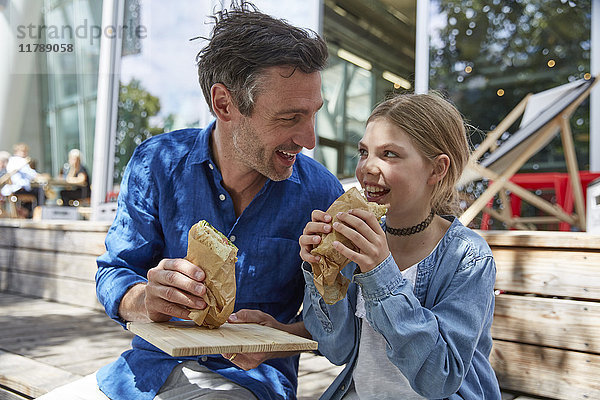 Vater und Tochter bei einem Snack in einem Outdoor-Café