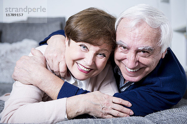 Seniorenpaar auf der Couch liegend  umarmend