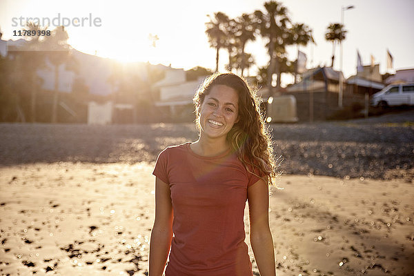 Porträt einer glücklichen Frau am Strand in der Abenddämmerung