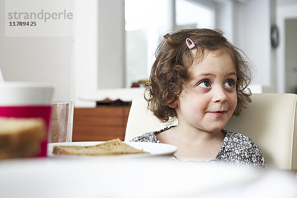 Porträt des lächelnden Mädchens am Frühstückstisch