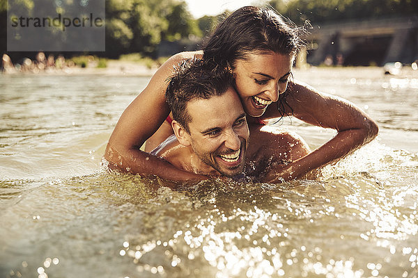 Lachendes Paar beim gemeinsamen Baden im Fluss
