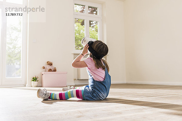 Mädchen in leerer Wohnung mit VR-Brille