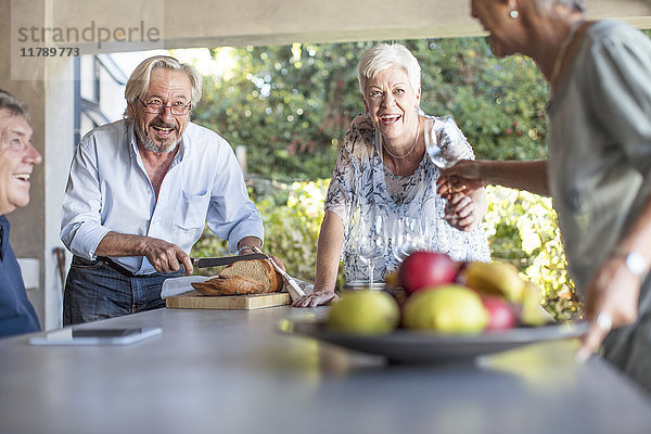 Zwei Seniorenpaare beim gemeinsamen Vergnügen auf der Terrasse