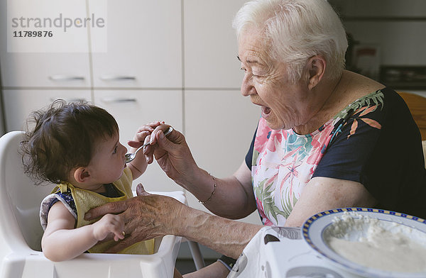 Großmutter füttert Baby in der Küche