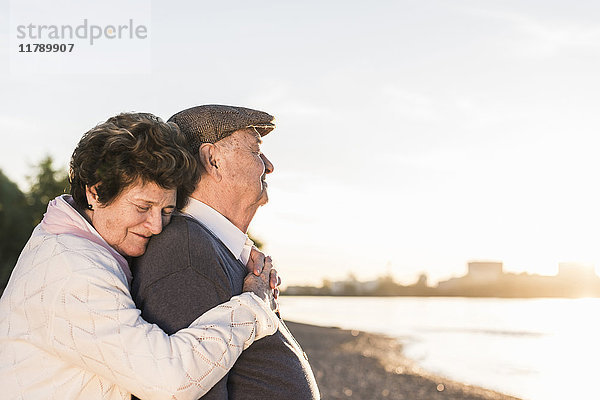 Glückliches Seniorenpaar am Strand bei Sonnenuntergang