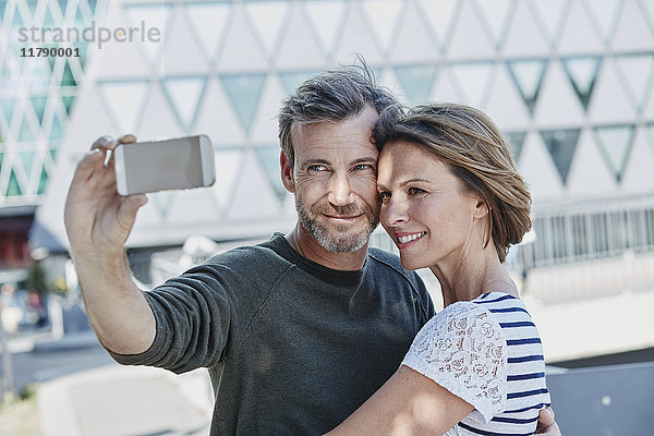 Ein glückliches reifes Paar  das einen Selfie nach draußen bringt.