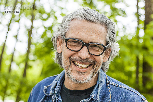 Porträt eines lachenden Mannes mit grauen Haaren und Bart mit Brille