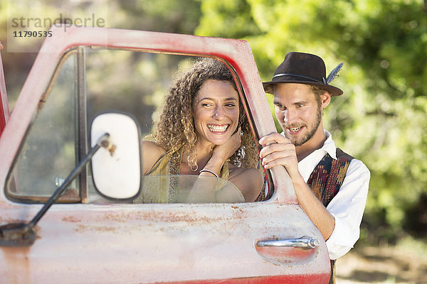 Fröhliches junges Paar beim alten Pickup