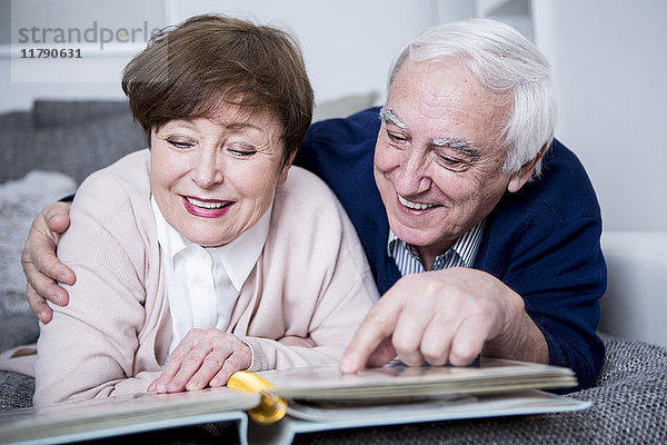 Seniorenpaar auf der Couch liegend  Blick auf Fotoalbum