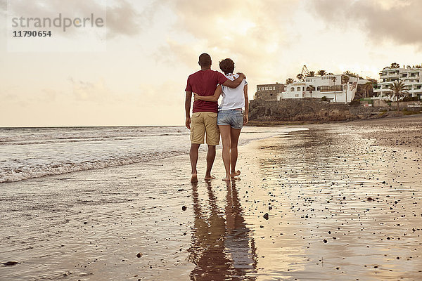 Spanien  Kanarische Inseln  Gran Canaria  Rückansicht des verliebten Paares beim Spaziergang am Strand