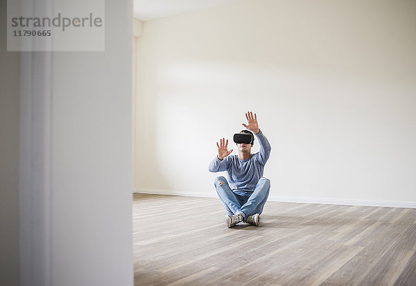 Mann in leerer Wohnung mit VR-Brille