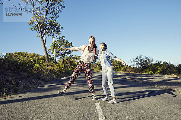 Südafrika  Kapstadt  Signal Hill  zwei glückliche junge Frauen auf der Landstraße
