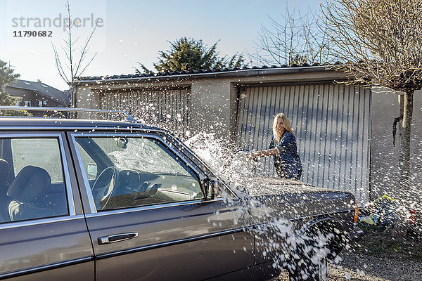 Frau wäscht ihr Auto