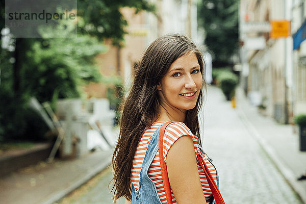 Porträt einer lächelnden jungen Frau in der Stadt