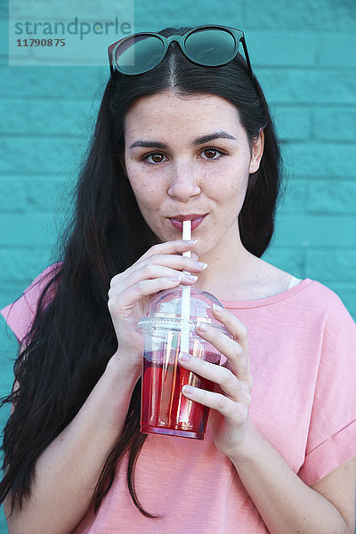Porträt einer jungen Frau beim Trinken von Erfrischungsgetränken