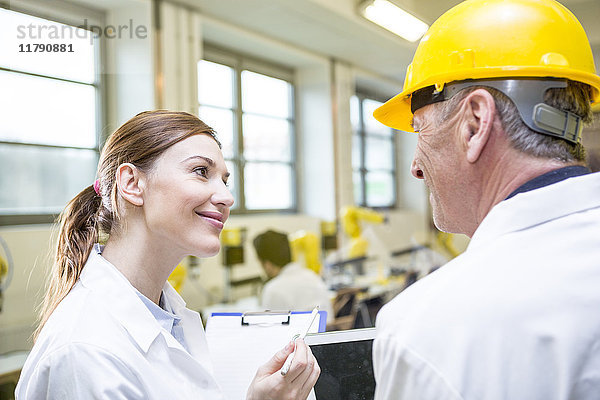 Zwei lächelnde Ingenieure in der Fabrik