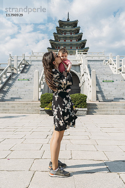 Südkorea  Seoul  Frau hält und küsst ein kleines Mädchen vor dem National Folk Museum of Korea  im Gyeongbokgung Palace.