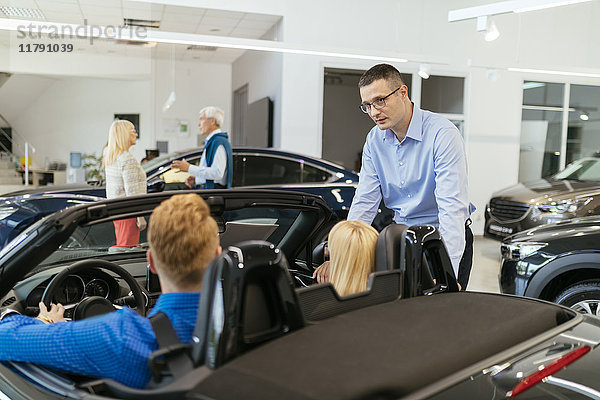 Verkäufer berät Kunden im Autohaus