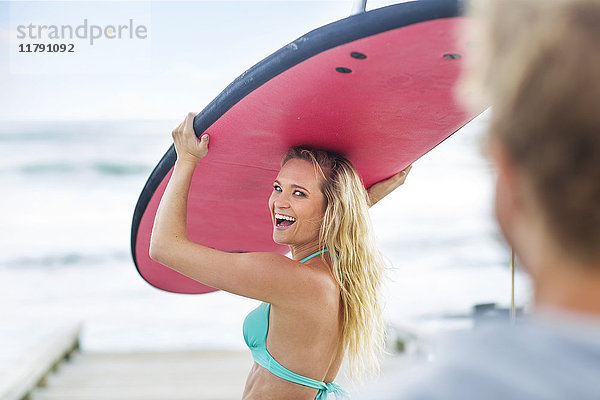 Glückliche Frau mit Surfbrett