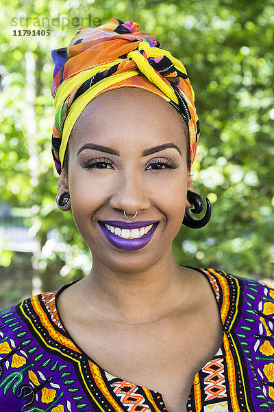 Porträt einer glücklichen jungen Frau mit Piercings in traditioneller brasilianischer Kleidung