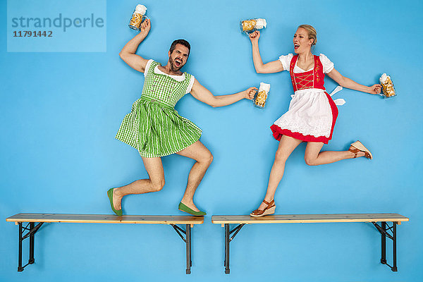 Mann und Frau auf dem Oktoberfest tanzen auf Bierbänken