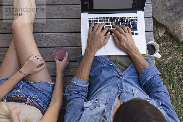 Overhead-Ansicht des Mannes auf der Terrasse mit Laptop neben der Frau