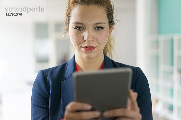 Geschäftsfrau betrachtet digitales Tablett