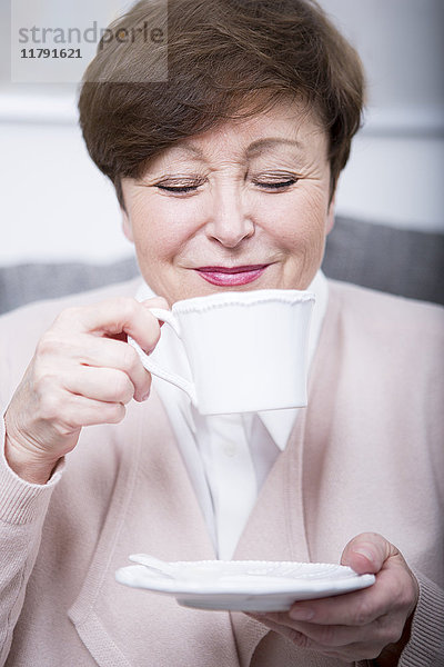 Porträt einer älteren Frau beim Kaffeetrinken