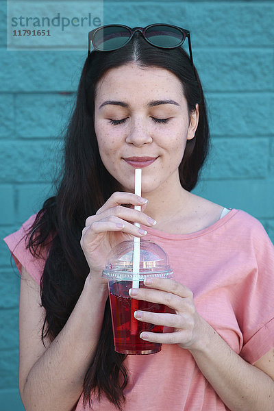 Porträt einer jungen Frau mit Erfrischungsgetränk