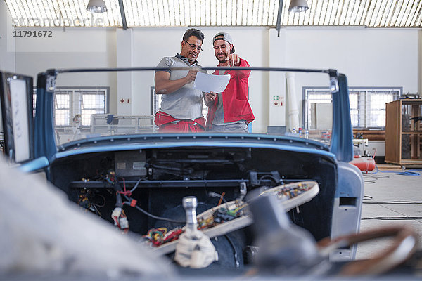 Mechaniker restaurieren Oldtimer in der Werkstatt