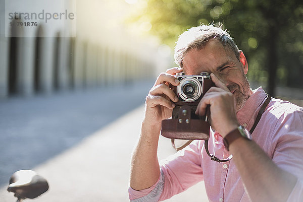 Mann fotografiert mit einer altmodischen Kamera im Park