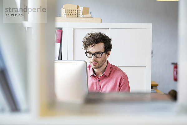 Mann im Büro mit Blick auf den Computerbildschirm