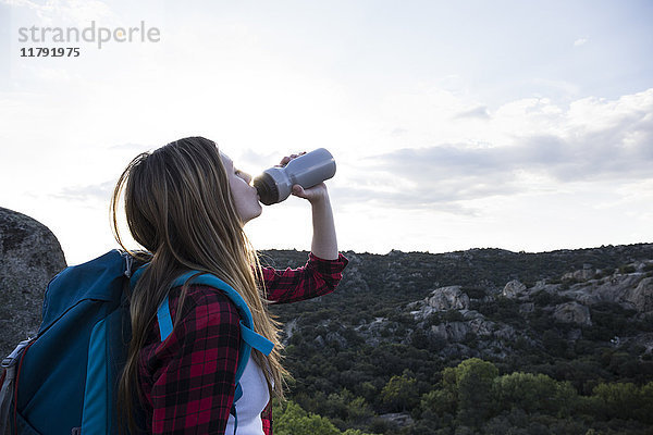 Spanien  Madrid  junge Frau trinkt während eines Trekking-Tages