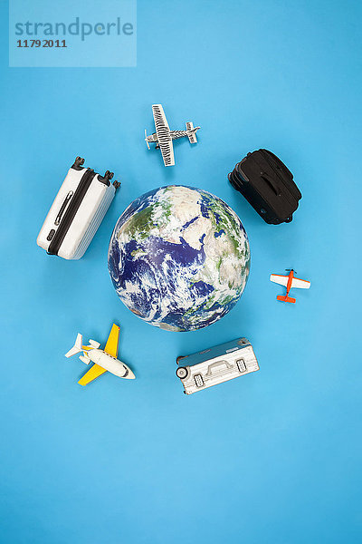 Koffer und Flugzeuge  die um den Globus fliegen