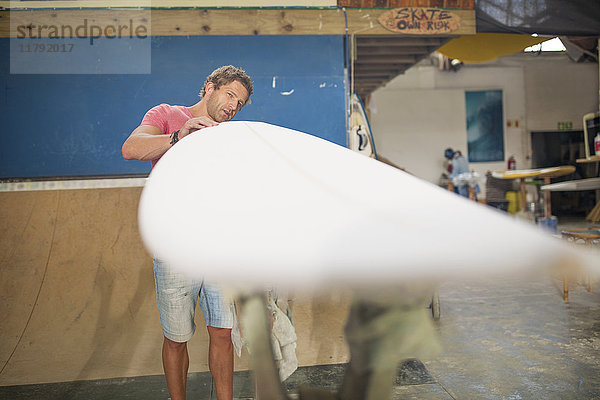 Surfboard Shaper Workshop  Mann überprüft Surfbrett