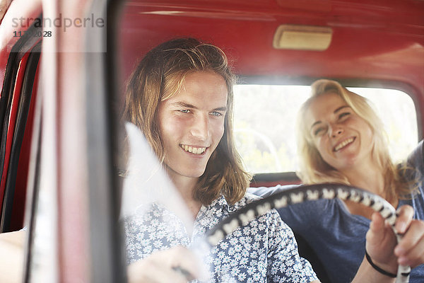 Glückliches junges Paar in einem alten Pick-Up