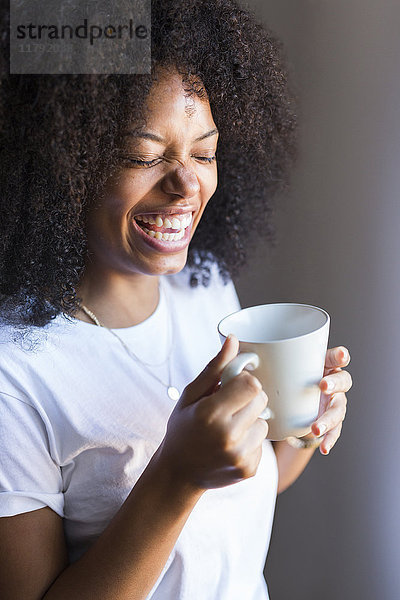 Lachende Frau mit einer Tasse Kaffee